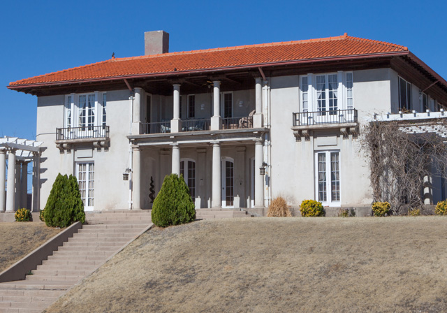 Italianate style home with balconies, columns and a terra cotta roof