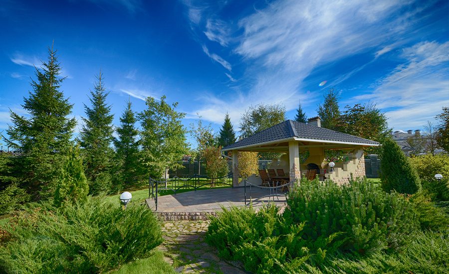Park pavilion surrounded by trees and landscaped lawn